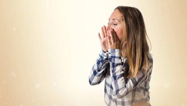 Amateur holka křičí na okrové pozadí — Stock fotografie