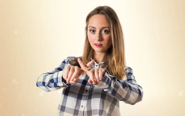 Blondes Teenie-Mädchen macht keine Geste auf ockerfarbenem Hintergrund — Stockfoto