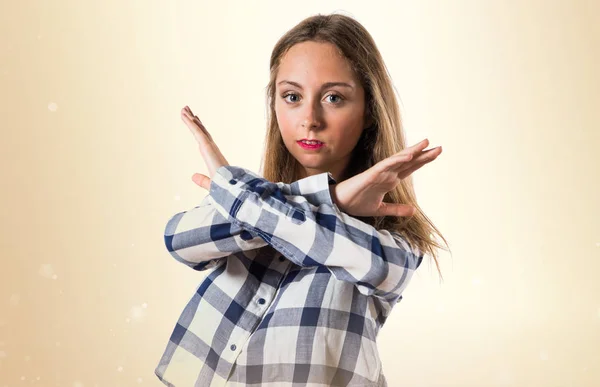 Szőke tini lány, így nem gesztus, okker háttér — Stock Fotó