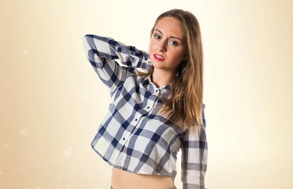 Blonde teen girl with neck pain on ocher background — Stock Photo, Image