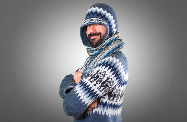 Hombre con ropa de invierno con los brazos cruzados sobre fondo gris — Foto de Stock