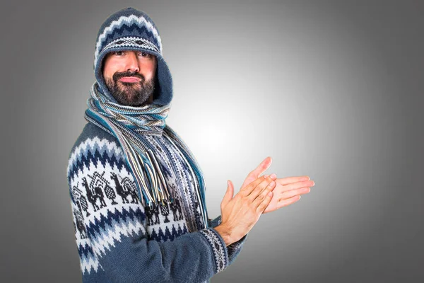 Adam gri arka plan üzerinde alkış kış giysileri ile