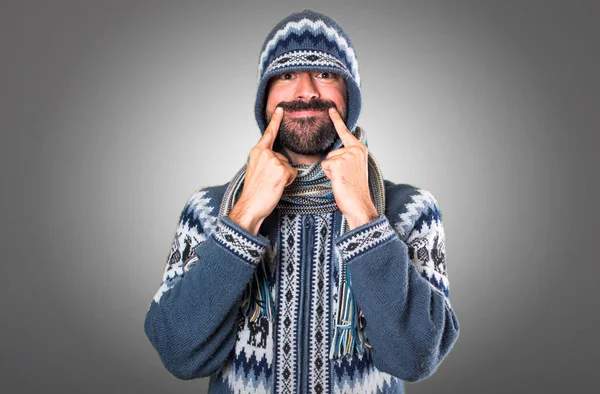 Gri arka plan üzerinde kış giysileri ile mutlu adam