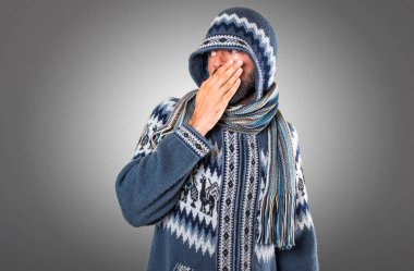 Adam ağzını gri arka plan üzerinde kapsayan kış giysileri ile