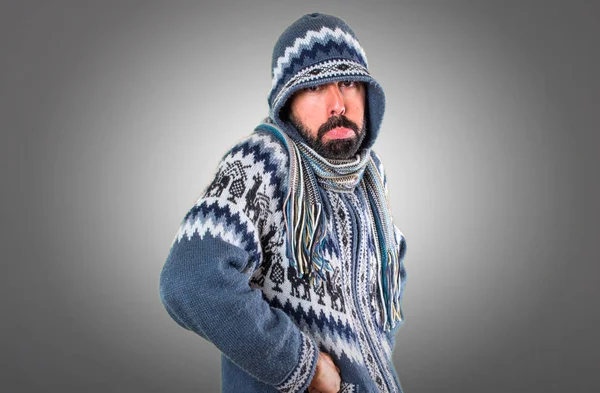 Hombre triste con ropa de invierno sobre fondo gris — Foto de Stock