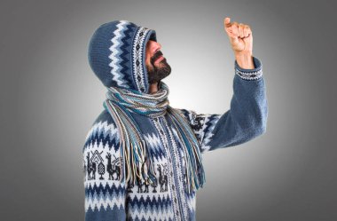 Adam küçük yapma kış giysileri ile gri arka plan üzerinde oturum