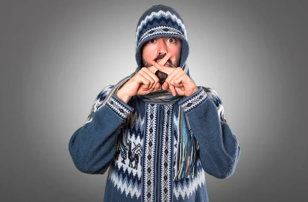 Man with winter clothes making silence gesture on grey backgroun — Stock Photo, Image