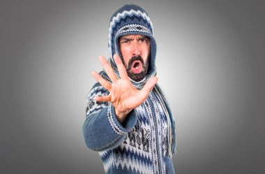 Adam dur işareti gri arka plan üzerinde yapma kış giysileri ile