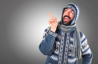 Adam gri arka plan üzerinde düşünme kış giysileri ile