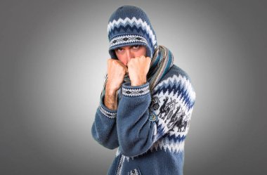 Adam gri arka plan üzerinde mücadele kış giysileri ile