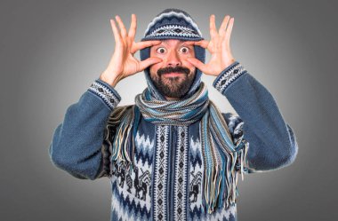 Adam bir şey gri arka plan üzerinde gösterilen kış giysileri ile