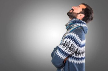 Adam gri arka plan üzerinde ararken kış giysileri ile