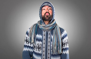 Adam gri arka plan üzerinde bir öpücük gönderme kış giysileri ile