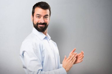 Sakal dokulu arka plan üzerinde alkış ile yakışıklı adam