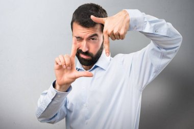 Sakal parmaklarıyla dokulu arka plan üzerinde odaklanan yakışıklı adam