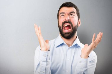 Dokulu arka plan üzerinde sakallı sinirli yakışıklı adam