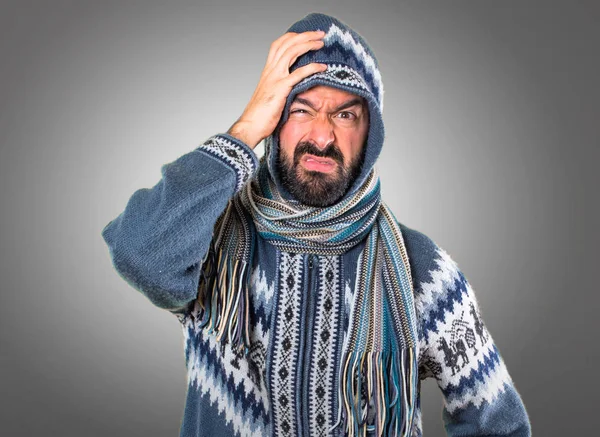 Gri arka plan üzerinde kış giysileri ile yorgun adam