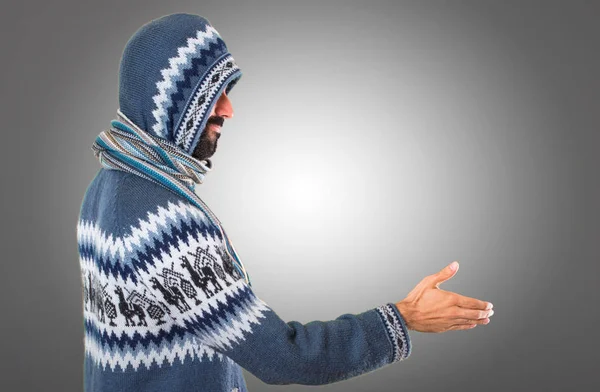 Adam kış giysileri gri arka plan üzerinde bir anlaşma ile