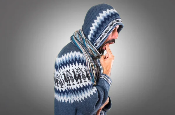 Adam kış giysileri üzerinde gri backgrou kusma jest yapma ile