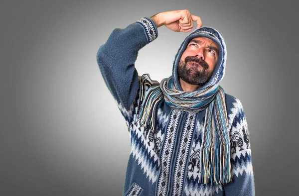 Adam gri arka plan üzerine şüpheleri kış giysileri ile