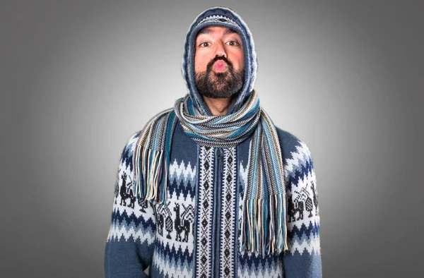 Adam gri arka plan üzerinde bir öpücük gönderme kış giysileri ile