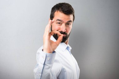 Ok işareti yapma sakallı yakışıklı adam dokulu arka plan