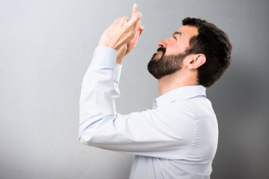 Parmaklarıyla dokulu arka plan üzerinde geçiş sakallı yakışıklı adam