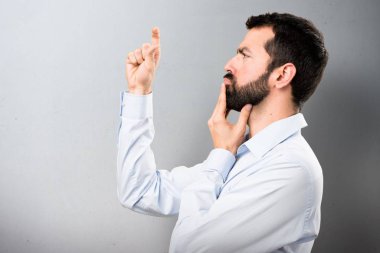 Küçük işareti üzerinde dokulu arka plan yapma sakallı yakışıklı adam