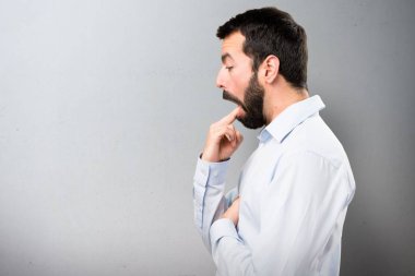 Dokulu arka plan üzerine kusma jest yapma sakallı yakışıklı adam