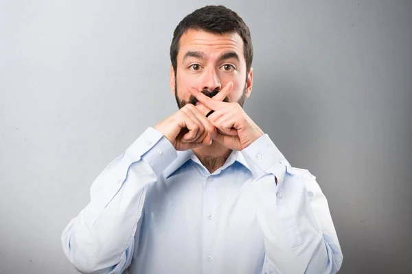 Bonito homem com barba fazendo gesto de silêncio sobre fundo texturizado — Fotografia de Stock