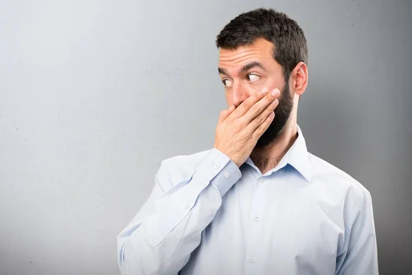 Hombre guapo con barba cubriéndose la boca sobre fondo texturizado —  Fotos de Stock