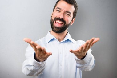 Bir şey üzerinde dokulu arka plan sunulması sakallı yakışıklı adam