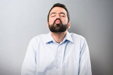 Dokulu arka plan üzerinde bir öpücük gönderme sakallı yakışıklı adam