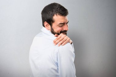 Omuz ağrısı dokulu arka plan üzerinde olan sakallı yakışıklı adam