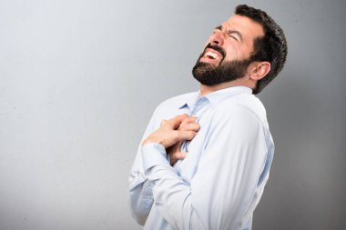 Kalp ağrısı dokulu arka plan üzerinde olan sakallı yakışıklı adam