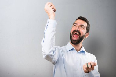 Poker fişleri dokulu arka plan üzerinde tutarak sakallı mutlu yakışıklı adam