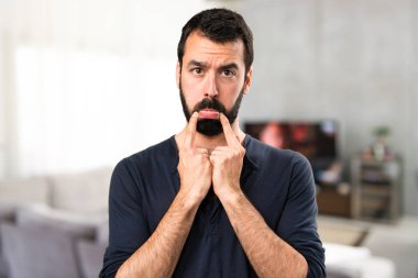 Evin içinde sakallı üzgün yakışıklı adam