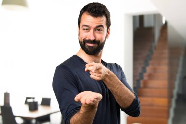 Bir şey evin içinde tutan sakallı yakışıklı adam