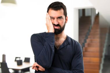 Evin içinde sakallı yorgun yakışıklı adam