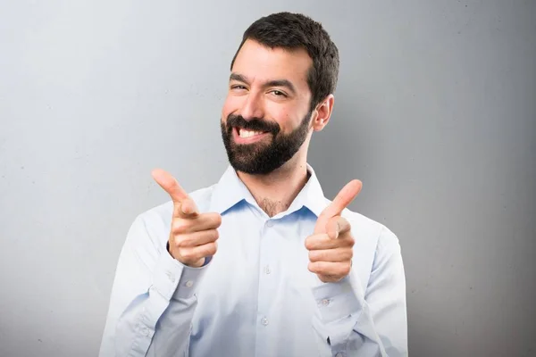 Knappe man met baard die wijzen op de voorkant op gestructureerde achtergrond — Stockfoto