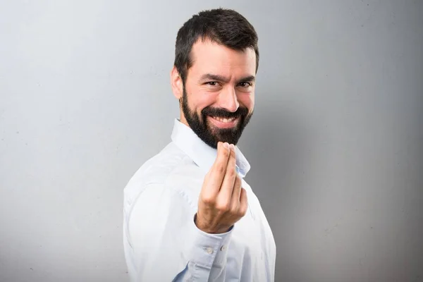 Bonito homem com barba fazendo gesto de dinheiro em fundo texturizado — Fotografia de Stock