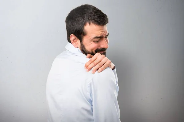 Omuz ağrısı dokulu arka plan üzerinde olan sakallı yakışıklı adam — Stok fotoğraf