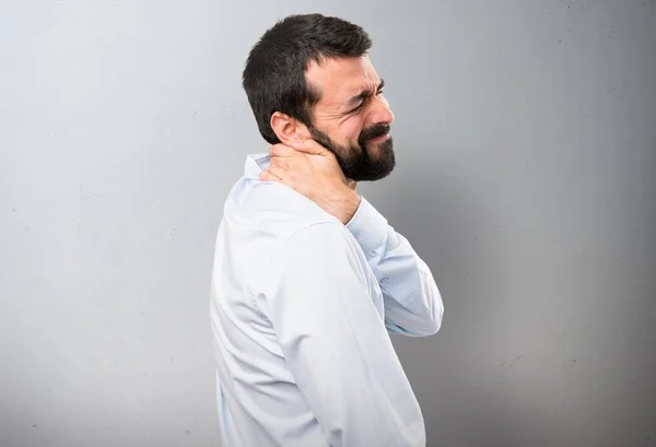 Boyun ağrısı dokulu arka plan üzerinde olan sakallı yakışıklı adam — Stok fotoğraf