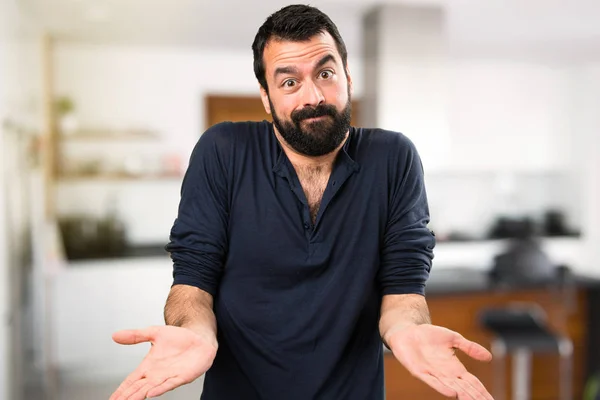 Bel homme avec barbe faire un geste sans importance à l'intérieur de la maison — Photo