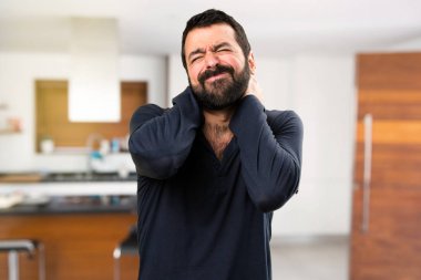 Evin içinde boyun ağrısı ile sakallı yakışıklı adam