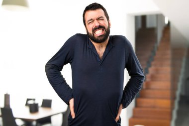 Evin içinde sırt ağrısı ile sakallı yakışıklı adam