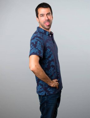 Esmer adam gri arka plan üzerinde bir şaka yapmak