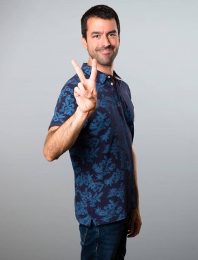 Esmer adam iki gri arka plan üzerinde sayma