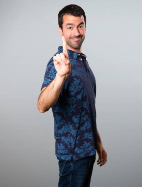 Esmer adam bir gri arka plan üzerinde sayma