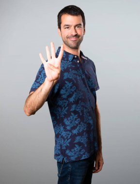 Esmer adam dört gri arka plan üzerinde sayma